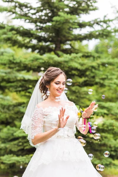 Jovem noiva brincar com bolha de sabão e alegria sorriso — Fotografia de Stock