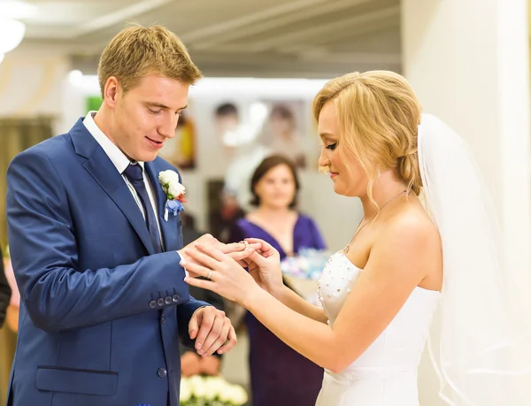 Bruid uitglijden ring aan de vinger van de bruidegom op de bruiloft — Stockfoto