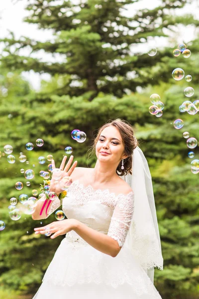 Jovem noiva brincar com bolha de sabão e alegria sorriso — Fotografia de Stock