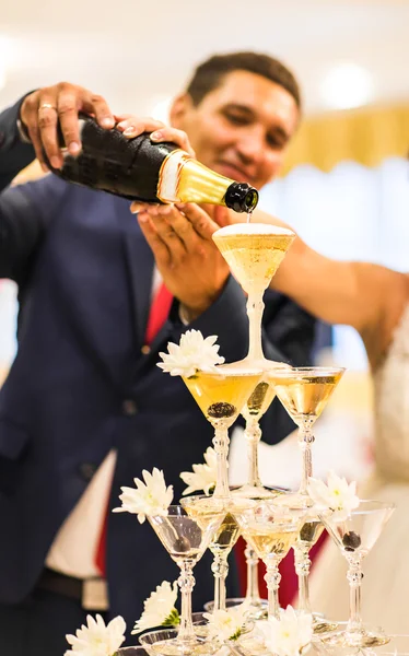 Bruid en bruidegom gieten champagne in het glas. — Stockfoto