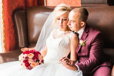 Gelin ve damat lüks bir sandalyede oturuyor. Seven çift birlikte kapalı.