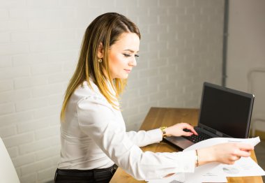 Ofisinde not defteri olan genç ve güzel bir iş kadını.