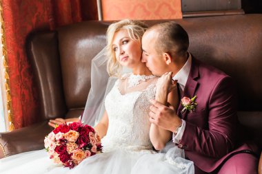 Gelin ve damat lüks bir sandalyede oturuyor. Seven çift birlikte kapalı.