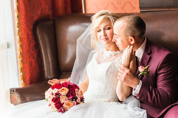 Braut und Bräutigam sitzen in einem luxuriösen Stuhl. Liebespaar zusammen drinnen. — Stockfoto