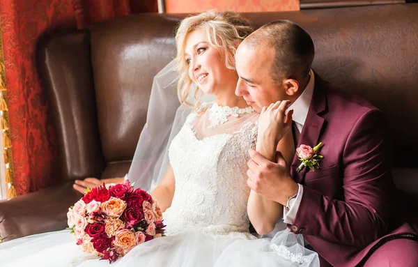 Novia y novio sentados en una silla de lujo. Pareja amorosa juntos en el interior . — Foto de Stock