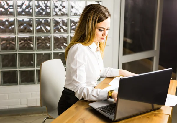 Porträt einer seriösen Geschäftsfrau mit Laptop im Büro. — Stockfoto
