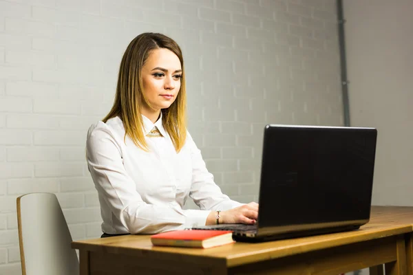 Portrait d'une femme d'affaires sérieuse utilisant un ordinateur portable au bureau. — Photo