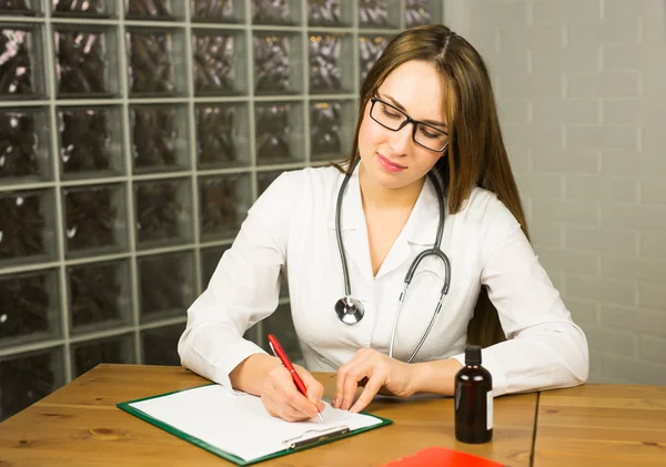 Kobieta lekarz pisze recepty — Zdjęcie stockowe