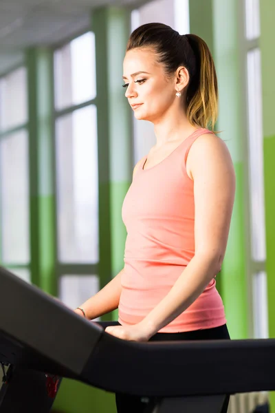 Fitness lány fut futópadon. Nő izmos lábak tornaterem — Stock Fotó