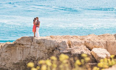 Turkuaz su arka plan ile tropik sahilde sarılma aşık Çift