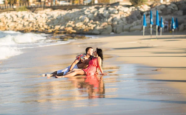 Jovem casal apaixonado beijando na areia — Fotografia de Stock