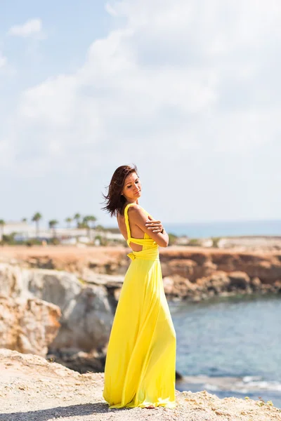 Piękna kobieta w żółtej sukience na plaży. — Zdjęcie stockowe