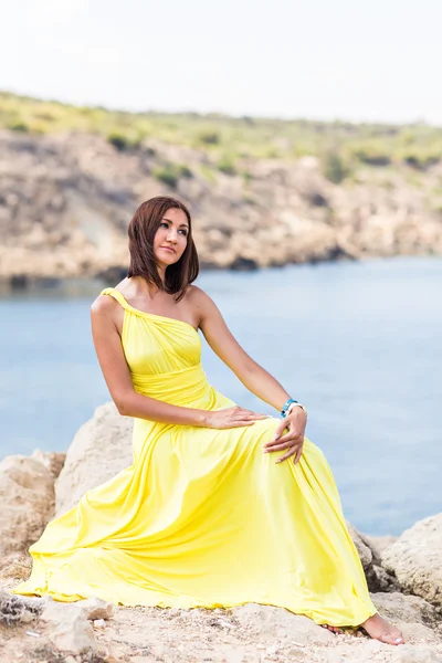 Hermosa mujer en vestido amarillo en la playa . — Foto de Stock