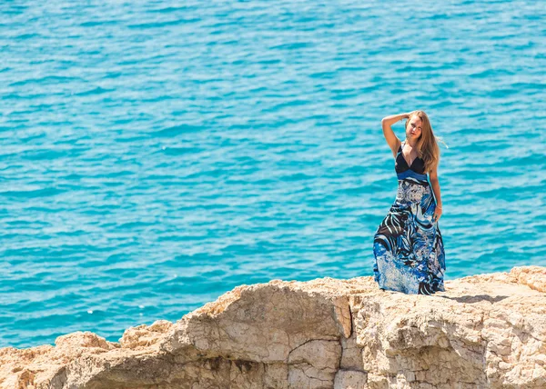 Молода красива біла жінка на скелі над морем — стокове фото