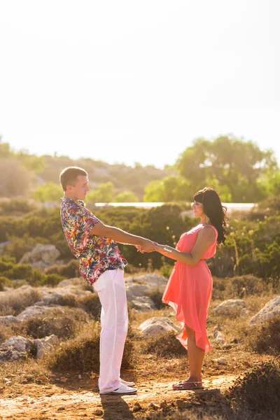 Casal jovem de mãos dadas e olhando um para o outro no dia ensolarado de verão . — Fotografia de Stock