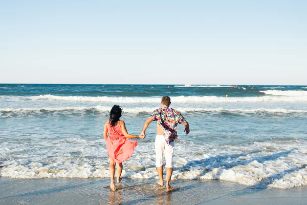 Casal feliz correndo na praia tropical, férias — Fotografia de Stock