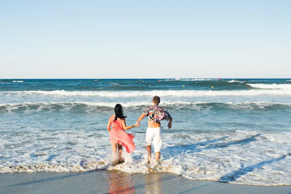 Casal feliz correndo na praia tropical, férias — Fotografia de Stock