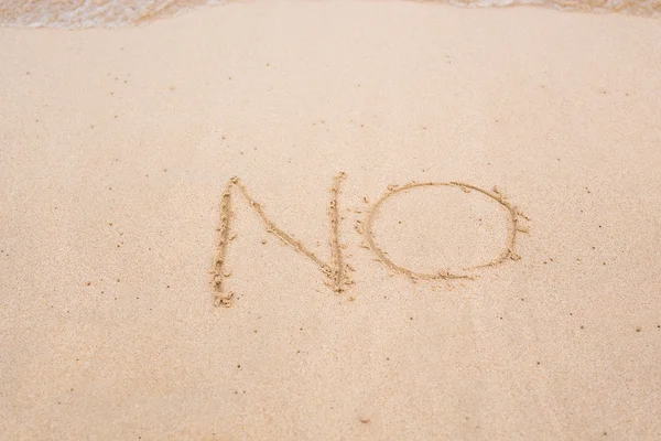 Geen teken geschreven in zand op strand textuur zonnige achtergrond. Closeup — Stockfoto