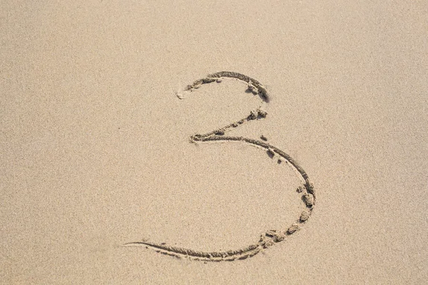 Nummer tre skriven i sanden. — Stockfoto