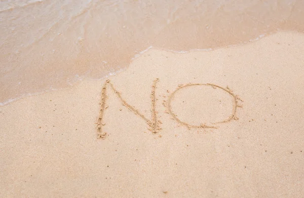 NÃO há sinal escrito em areia na textura da praia fundo ensolarado. Fechar. — Fotografia de Stock