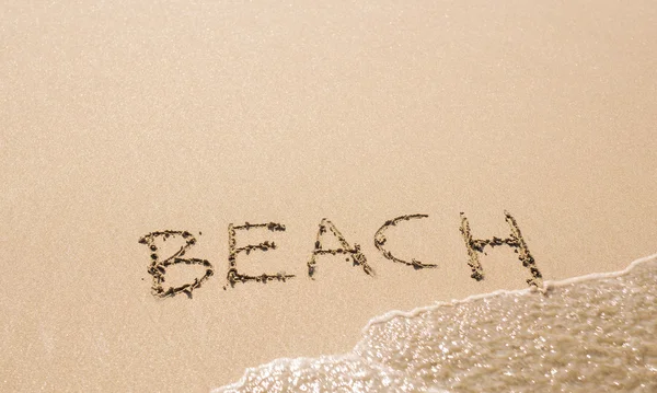 Woord strand geschreven op het zand — Stockfoto