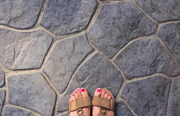 Fötterna selfie från övre syn på en kvinna resenär i sandal under en turné resa runt om i världen. Turist ta ett foto av hennes egna ben. — Stockfoto