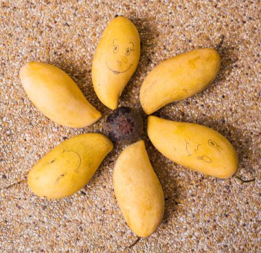 Gülen yüz bir mango meyve üzerinde çizilmiş. Meyve, beslenme, sağlıklı gıda kavramı