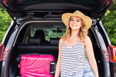 Tatil, seyahat kavramı - genç kadın bavullar ve araba ile yolculuk boyunca yaz tatili için hazır