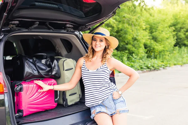 Dovolená, cestování koncept - mladá žena připravena na cestu o letních prázdninách s kufry a auto — Stock fotografie