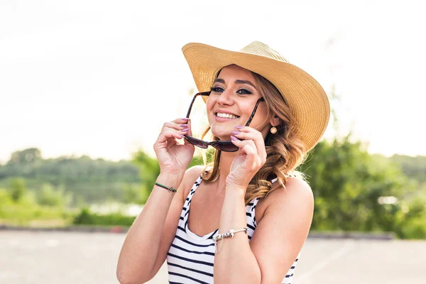 Glimlachende zomervrouw met hoed en zonnebril — Stockfoto