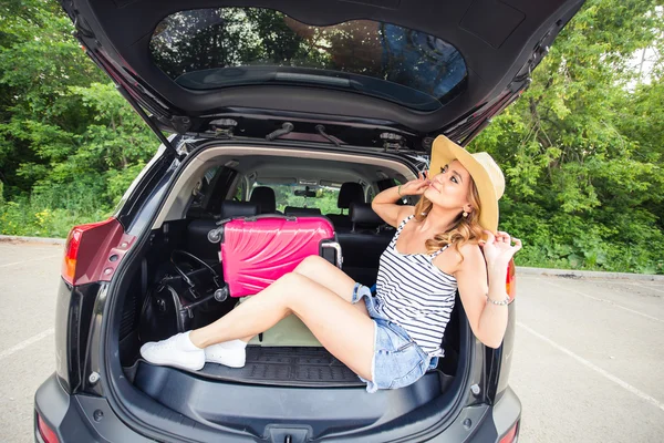 Nyaralás, utazás - fiatal nő készen áll az utazás. bőröndök és autó — Stock Fotó