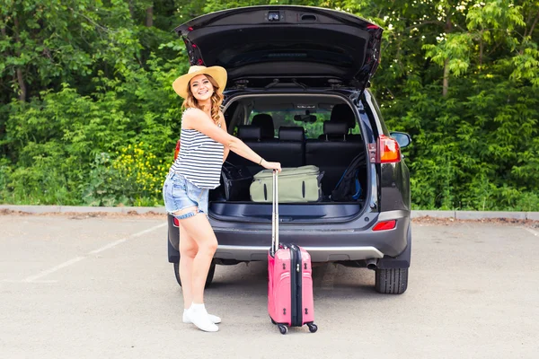 Dovolená, cestování - mladá žena připravena pro cestování. kufry a auto — Stock fotografie
