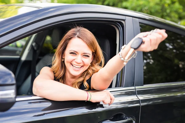 Junge Frau zeigt Schlüssel im Auto — Stockfoto