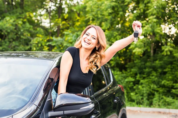Mladá žena zobrazeno klíče v autě — Stock fotografie