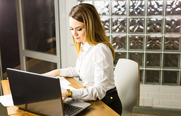 Portrait de belle jeune femme travaillant avec un ordinateur portable dans son bureau. — Photo