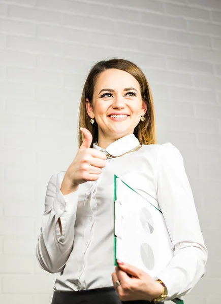 Feliz sonriente mujer de negocios con los pulgares hacia arriba gesto y carpeta . — Foto de Stock