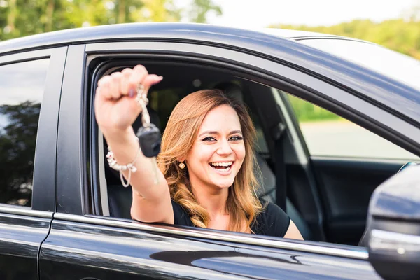 Autofahrerin mit Autoschlüssel fährt ihr neues Auto lachendes junges Mädchen — Stockfoto