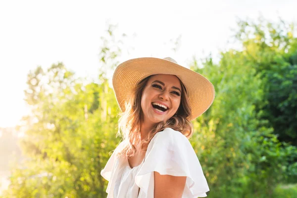 Riendo joven mujer disfrutando de su tiempo fuera en el parque con puesta de sol en el fondo . — Foto de Stock