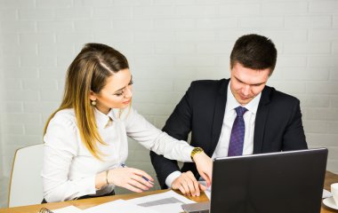 Belgeleri karşılaştırma bir Ofis Masası birlikte çalışan oturan iki girişimciler.