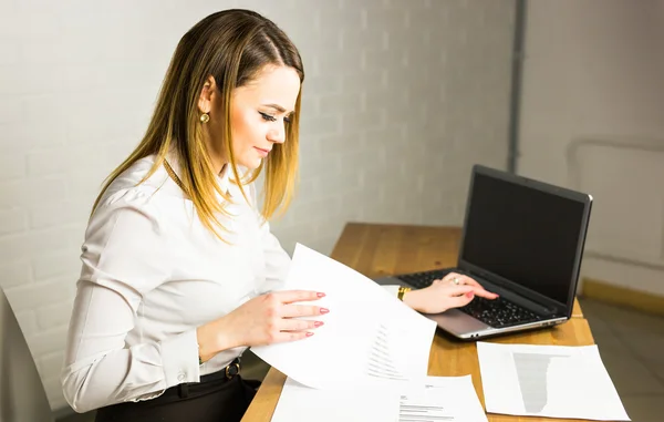 Heureuse femme d'affaires travaillant sur l'ordinateur portable au bureau — Photo