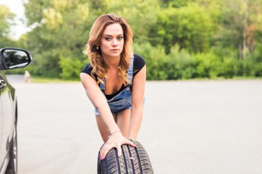 Kadın bir yolda lastik değiştirme