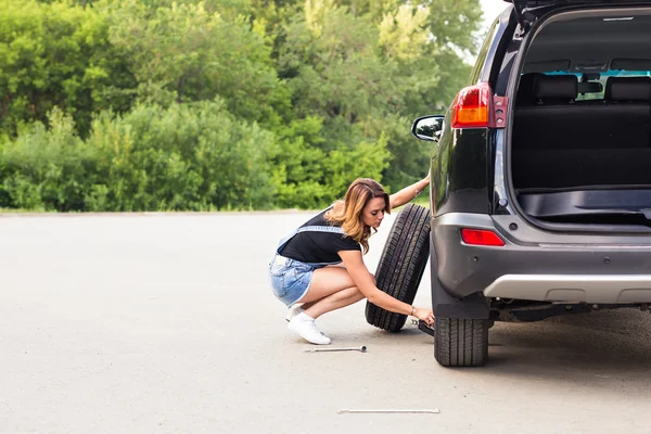 Ženy mění pneumatiky na silnici — Stock fotografie