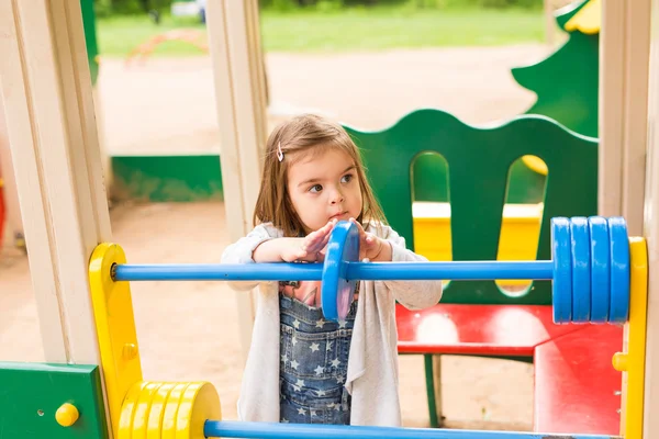 Dziewczynka na plac zabaw. Dziecko bawiąc się na zewnątrz w lecie. — Zdjęcie stockowe