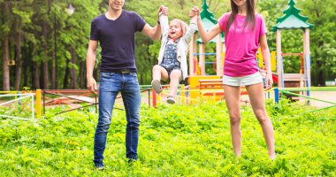 Baba, kız ve anne dışarıda yürüyor. Mutlu aile.