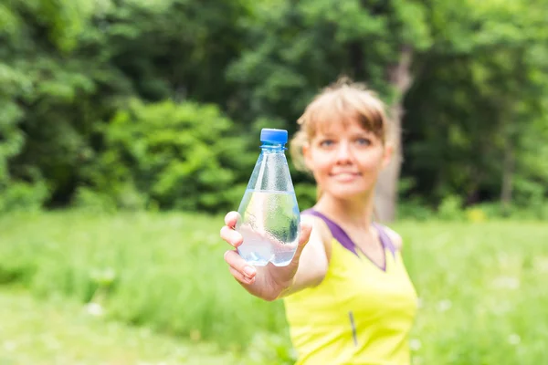 Jeune femme de fitness avec bouteille d'eau. Focus sur la bouteille — Photo