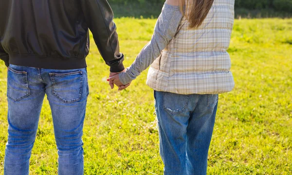 Gros plan d'un couple amoureux marchant dans le parc d'automne se tenant la main regardant au coucher du soleil . — Photo