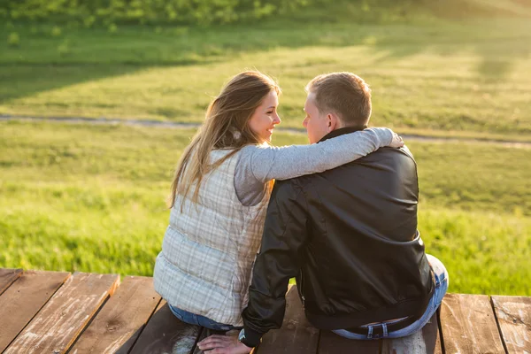 Joven pareja sentarse y abrazo juntos en al aire libre . — Foto de Stock