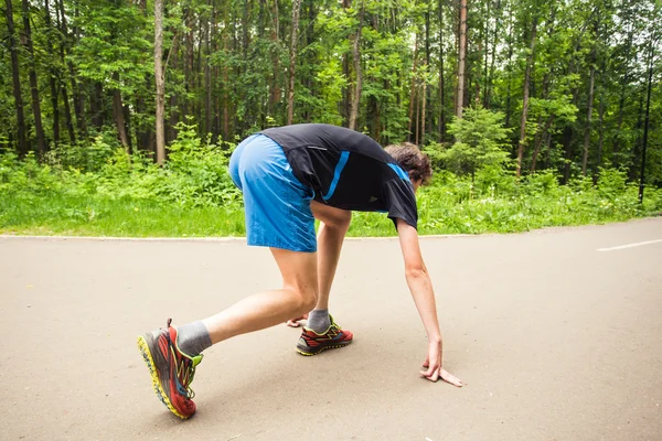 Fiatal férfi futó futni a pályán való felkészülés — Stock Fotó