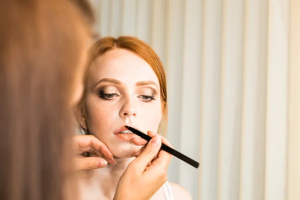 Retrato hermoso pelo largo rojo chica y maquillaje estilista — Foto de Stock