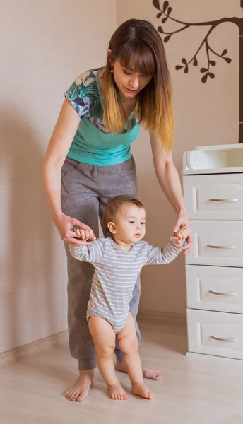 Passi bambino con l'aiuto di sua madre — Foto Stock